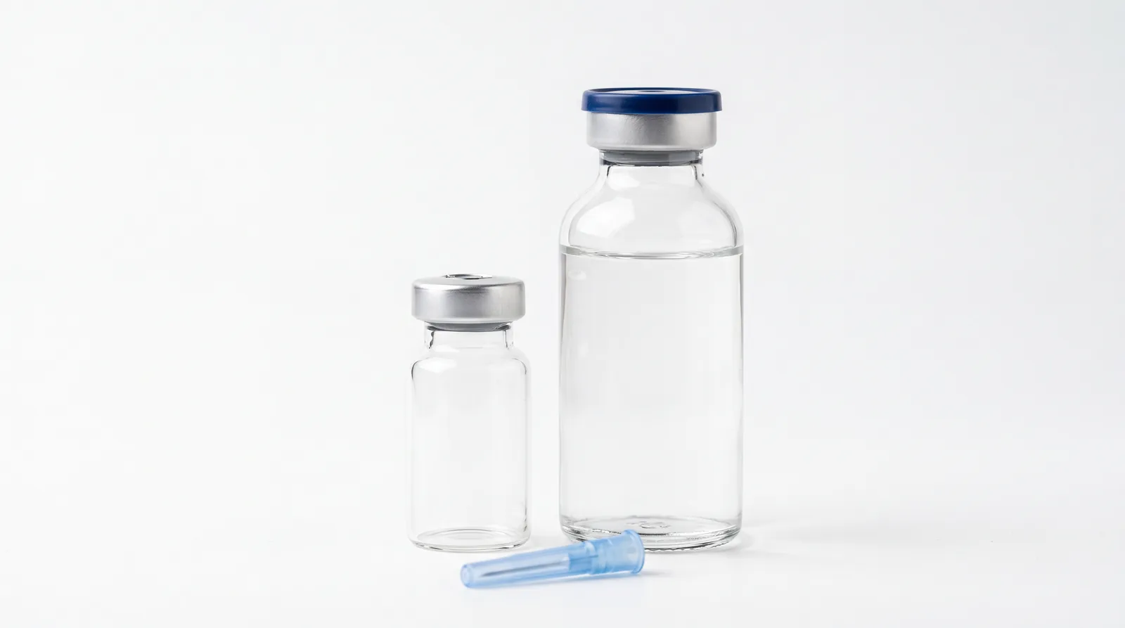 Unlabelled peptide vial standing beside a bottle of sterile water