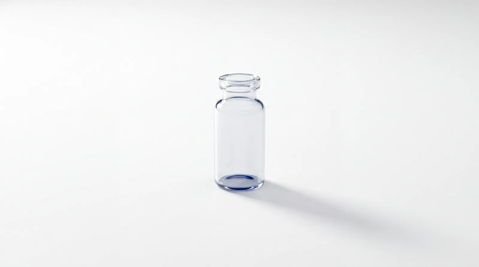 Single unlabelled vial alone in a large empty white space